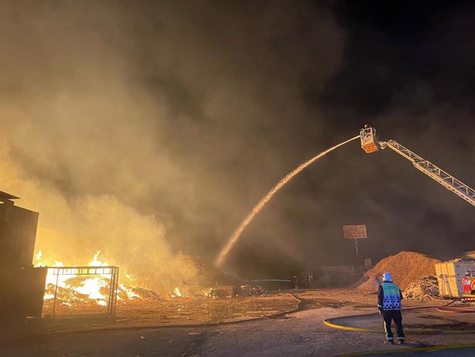 Bomberos trabajando en la extinción de un incendio en una planta de reciclaje de palets de madera en Cubas de la Sagra (Madrid)