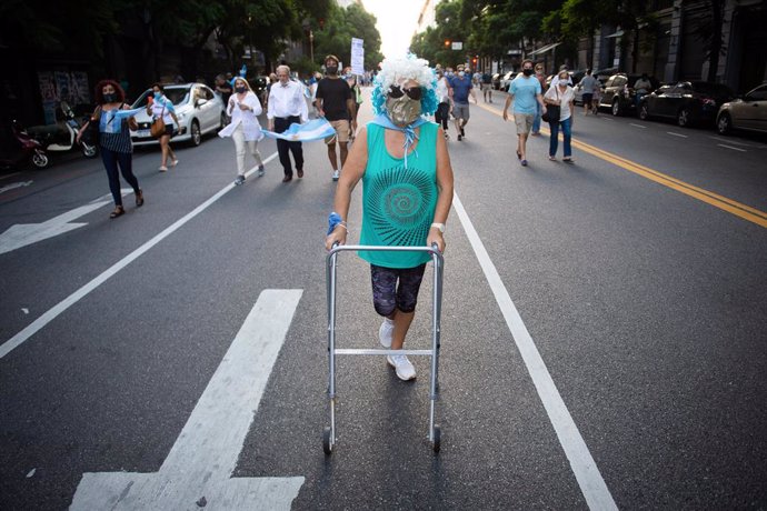 27 February 2021, Argentina, Buenos Aires: A protester with a walker takes part in a protest against the Argentinian government after the VIP vaccine rollout scandal. The government published a list of 70 public figures who have already received the cor