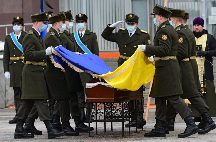 Archivo - 14 January 2021, Ukraine, Zaporizhzhia: People pay their respects to perished soldier Oleh Andriienko during his funeral ceremony outside the Zaporizhzhia Regional State Administration. The 37-year-old serviceman was shot dead by a sniper near