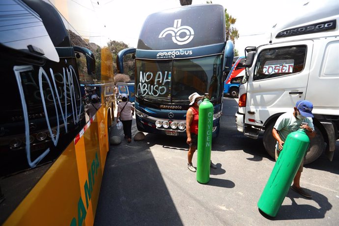 17 March 2021, Peru, Lima: People walk with oxygen tanks and try to find a way to refill their oxygen while transportation completely stopped as trucks drivers block the Central Highway from Ate to Chaclacayo during their two days strike. Photo: -/GDA v