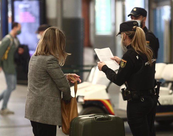 Agentes de la Policía Nacional piden justificantes durante controles de movilidad en la estación de tren de Atocha, en Madrid (España), a 26 de marzo de 2021