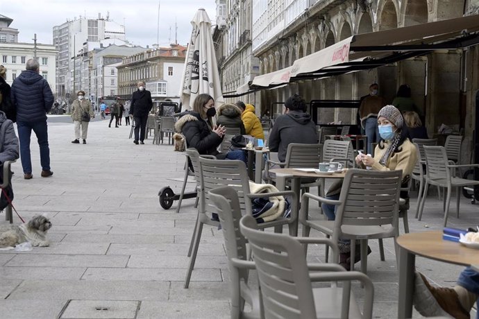 Varias personas en la terraza de un restaurante, en A Coruña, Galicia (España), a 19 de marzo de 2021. A Coruña se encuentra en el nivel medio de restricciones, en el que la hostelería cerrará a las 21 horas como en toda la comunidad, pero el aforo en e