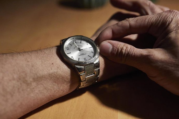 Un hombre cambia las manecillas de un reloj