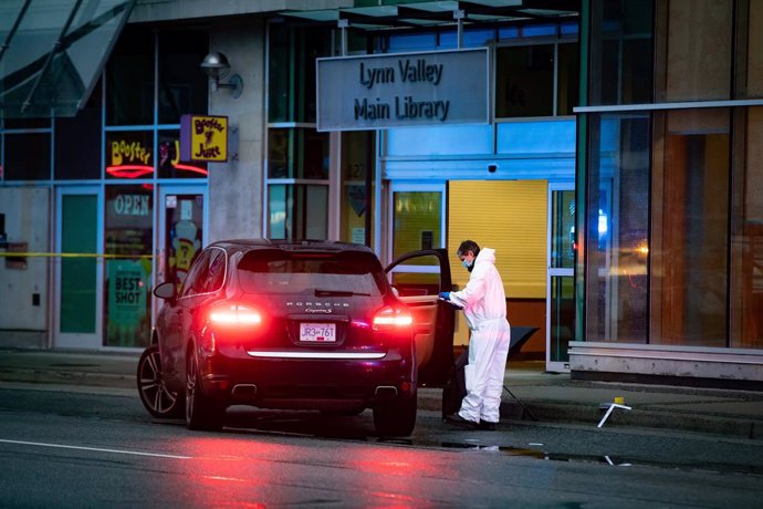 27 March 2021, Canada, North Vancouver: A forensics police officer collects evidence outside the entrance to the Lynn Valley Library. A woman is dead and six others injured after a stabbing on Saturday that police said they were trying to determine a mo