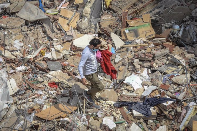 27 March 2021, Egypt, Cairo: A civilian carries his belongings at the site where a multi-storey building collapsed in Gesr al-Suez district. Egyptian media said the collapsing killed at least eight people and injured two dozen. Photo: Tarek Wajeh/dpa