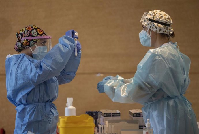 Archivo - Un trabajador sanitario sostiene una probeta en un dispositivo de cribado masivo de antígenos organizado para detectar positivos por coronavirus.
