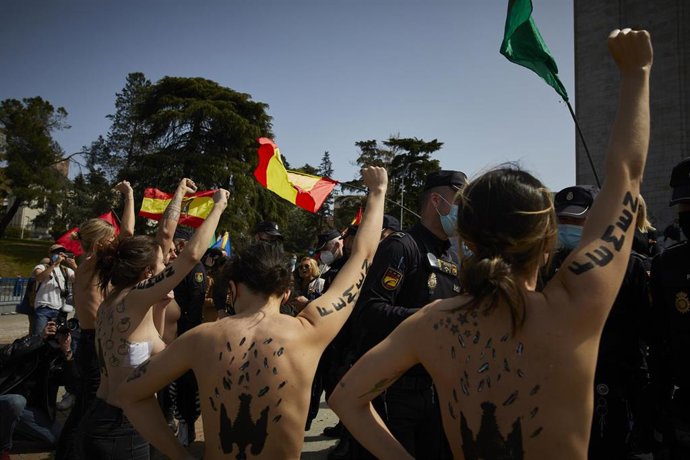 Varias activistas de Femen con águilas franquistas dibujadas en la espalda durante un acto por el Día de la Victoria en el LXXXII Aniversario de la Liberación de Madrid, en el Arco de la Victoria, en Madrid (España), a 28 de marzo de 2021.El colectivo