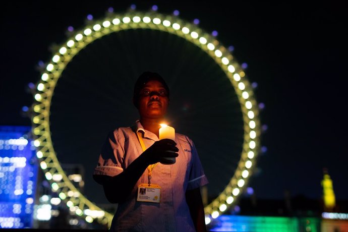 23 March 2021, United Kingdom, London: Nurse Sanyu Kasule stands at the London Eye in London to mark the National Day of Reflection, on the anniversary of the first national lockdown to prevent the spread of coronavirus. Photo: David Parry/PA Wire/dpa