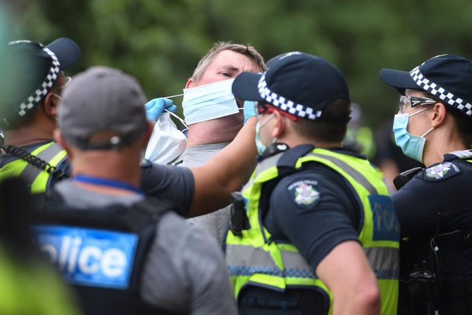 Archivo - Police attempt to put a mask on an arrested protester during an anti-vaccination rally in Melbourne, Saturday, February 20, 2021. The national rollout of the Pfizer vaccine will begin on Monday in what will be the largest exercise of its kind 