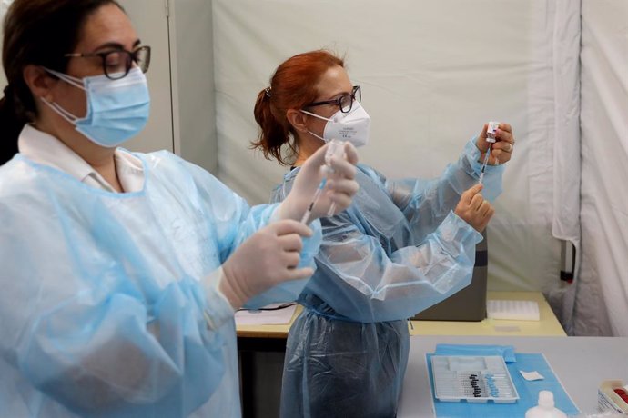 27 March 2021, Portugal, Lissabon: Health technicians fill up syringes with a dose of the AstraZeneca Coronavirus (Covid-19) vaccine at the Odivelas Multipurpose Pavilion. Photo: Pedro Fiuza/ZUMA Wire/dpa