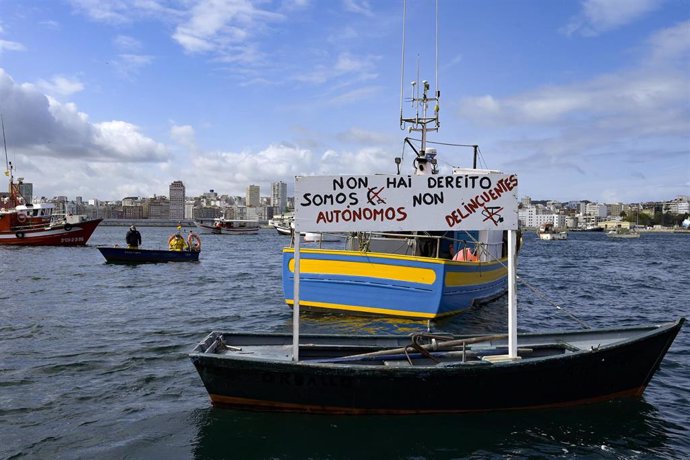Un barco de flota artesanal con un cartel en el que se lee: ` Non hai dereito, somos autónomos non delincuentes, tras la convocatoria de paro por parte de la Federación Galega de Cofradías de Pescadores en la dársena de A Marina en A Coruña, Galicia (Esp