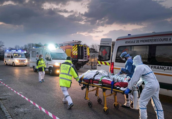 Archivo - 29 March 2020, France, Mulhouse: Emergency medical personnel transport a patient infected with the coronavirus from a military hospital to an ambulance to be transferred to another hospital by a TGV high-speed train. Photo: Sebastien Bozon/AFP