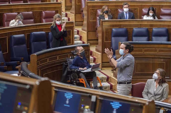 La ministra de Trabajo, Yolanda Díaz, aplaude al vicepresidente segundo del Gobierno, Pablo Iglesias (d), durante una sesión plenaria en el Congreso de los Diputados, Madrid, (España), a 24 de marzo de 2021.