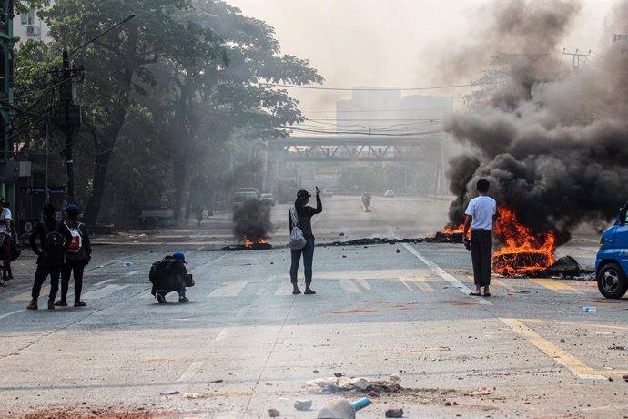 27 March 2021, Myanmar, Yangon: People stand near burning tires on the street during a demonstration against the military coup and the detention of civilian leaders. Photo: Santosh Krl/SOPA Images via ZUMA Wire/dpa