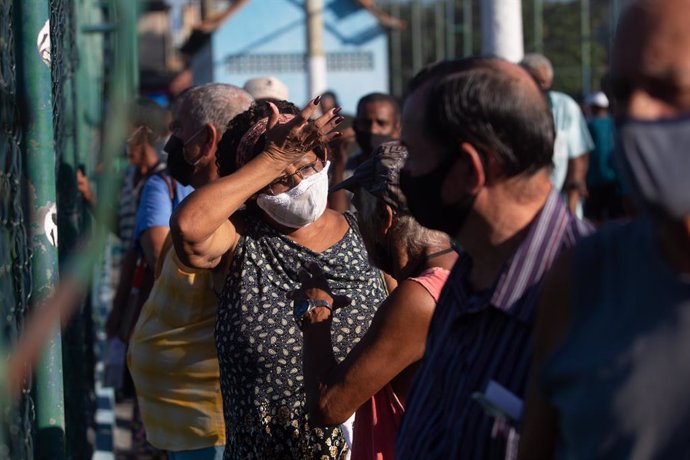 22 March 2021, Brazil, Duque De Caxias: People line up outside a vaccination center, where they will be administered a Coronavirus vaccine. Photo: Fernando Souza/dpa
