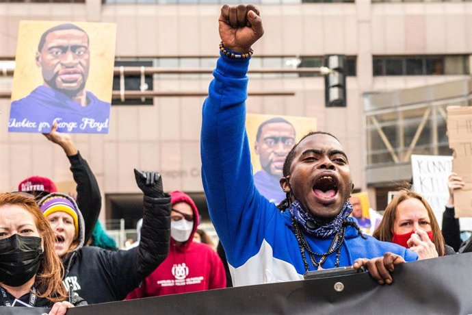28 March 2021, US, Minneapolis: People take part in a protest outside the Hennepin County Courthouse a day before the trial of Minneapolis police Officer Derek Chauvin in the death of George Floyd. Floyd is an African American man killed during an arres