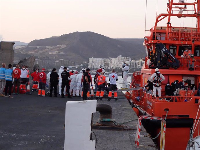MIembros de la Cruz Roja ayudan a bajar del barco a migrantes en el puerto de Arguineguín (foto recurso)