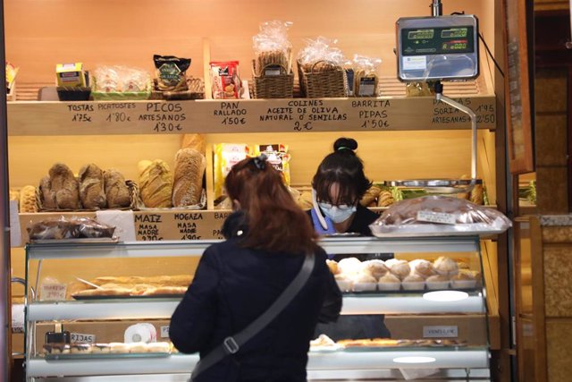 Archivo - Una mujer compra en una de las panaderías en Madrid