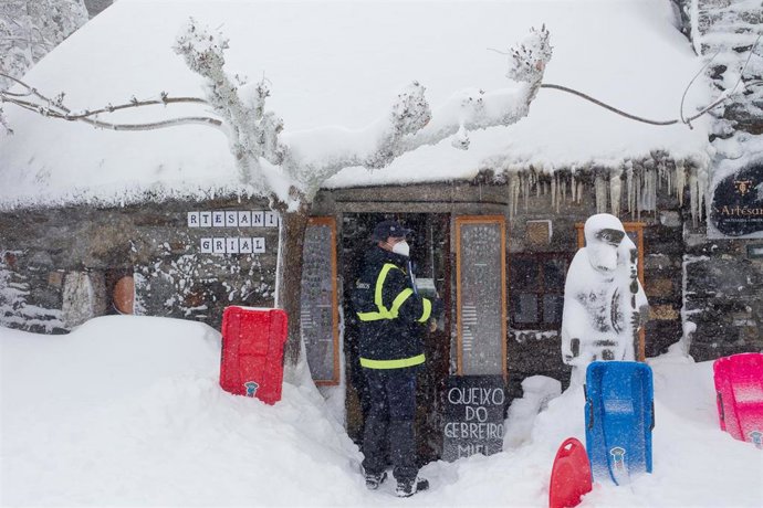 Archivo - Una trabajadora de Correos lleva correspondencia a una tienda de souvenirs en la parroquia de O Cebreiro, en Lugo, Galicia (España), a 29 de diciembre de 2020. El temporal de nieve ha dificultado la circulación en más de un centenar de carrete