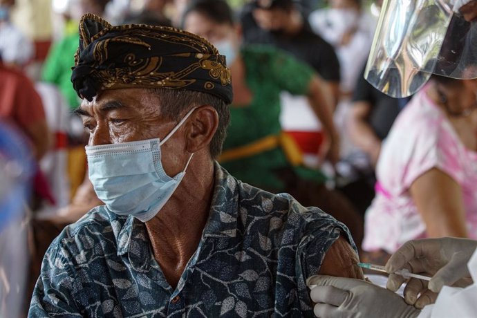 16 March 2021, Indonesia, Bali: A man receives a dose of a COVID-19 vaccine as part of a mass vaccination campaign. Photo: Dicky Bisinglasi/ZUMA Wire/dpa