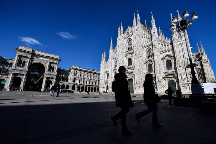 15 March 2021, Italy, Milan: Few pedestrians walk across the almost deserted Duomo square,on the first day of the newly reimposed restrictions to curb the spreading of coronavirus. Photo: Claudio Furlan/LaPresse via ZUMA Press/dpa