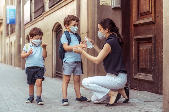 Archivo - Uso de geles hidroalcohólicos  en niños. Madre con dos niños.