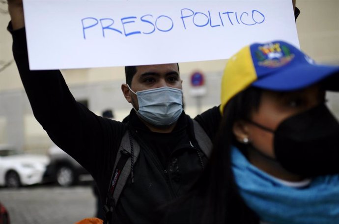 Archivo - Un hombre sostiene una pancarta donde se puede leer "Preso político" en una concentración de apoyo al opositor venezolano Ernesto Quintero ante su inminente extradición desde España.
