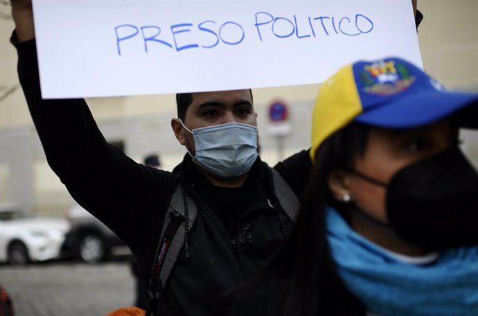 Archivo - Un hombre sostiene una pancarta donde se puede leer "Preso político" en una concentración como signo de apoyo a la mujer de Ernesto Quintero, el venezolano que fue detenido este miércoles por la Policía Nacional para ser extraditado a Venezuel