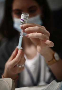 Una profesional sanitaria sostiene una jeringuilla con un vial de la vacuna contra la COVID-19 