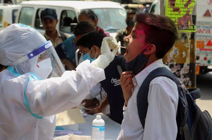 26 March 2021, India, New Delhi: A health worker wearing personal protective equipment collects a swab sample from a student for Coronavirus (Covid-19) test in the road side at Shalimar Bagh. Photo: Naveen Sharma/SOPA Images via ZUMA Wire/dpa