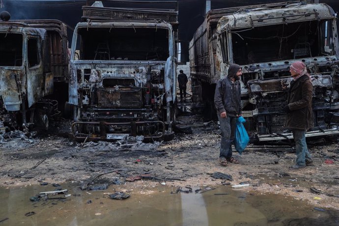 22 March 2021, Syria, Idlib: Syrians inspect the damage in the aftermath of an airstrike that was allegedly carried out by Russian warplanes on a truck depot near Bab al-Hawa border crossing on the Syrian-Turkish border. Photo: Anas Alkharboutli/dpa
