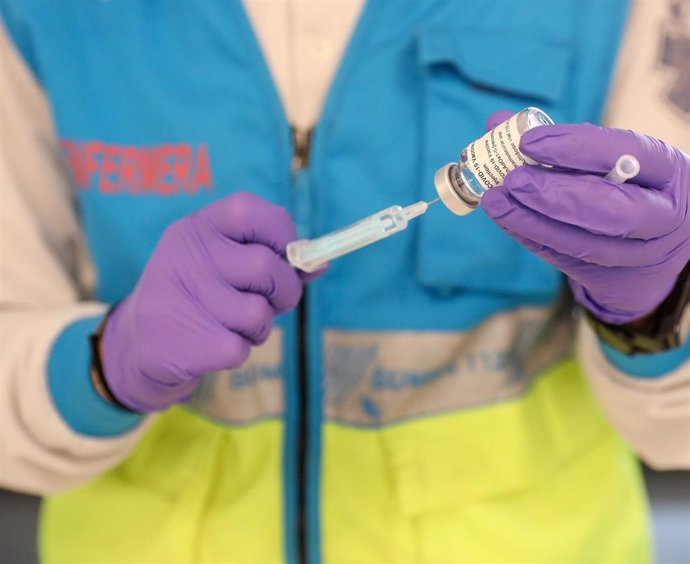 Un profesional sanitaria sostiene una jeringuilla y un vial con la vacuna del Covid-19, en un dispositivo instalado en el Estadio Wanda Metropolitano, en Madrid (España), a 30 de marzo de 2021.