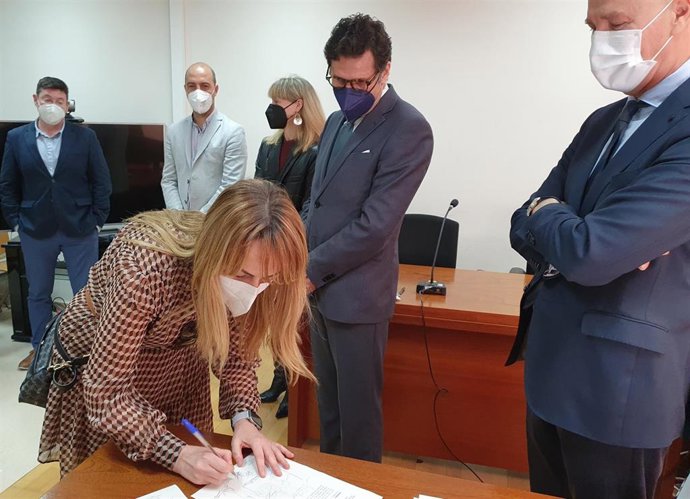 Una funcionaria firma el acta de toma de posesión en presencia del presidente del TSJ, el secretario de Gobierno, la magistrada decana, el alcalde y un concejal de Molina de Segura