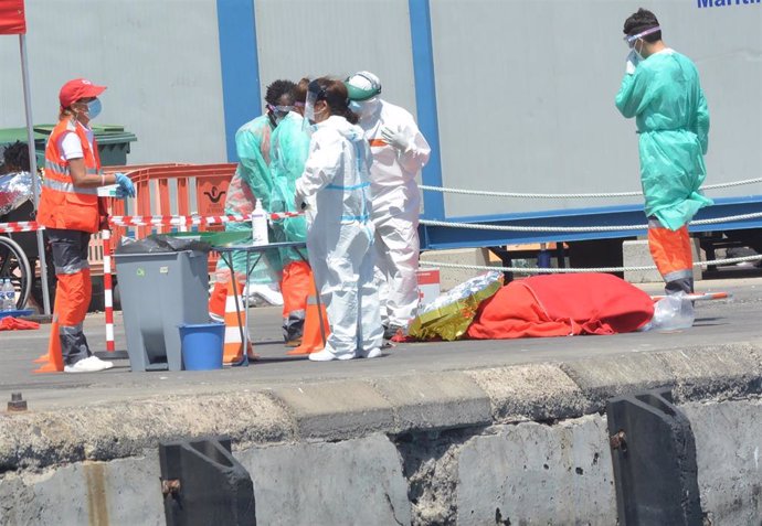 Personal de Salvamar Alpheratz y de la Cruz Roja atienden a migrantes procedentes de una patera en el Puerto de los Cristianos, en Tenerife, Canarias (España), a 26 de marzo de 2021. Dos mujeres y un hombre han muerto y otras 41 personas han sido rescat