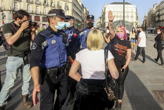 Una neonazi realiza el saludo romano frente a una concentración a favor de los derechos de las personas transgénero, en Madrid (España), a 31 de marzo de 2021. 