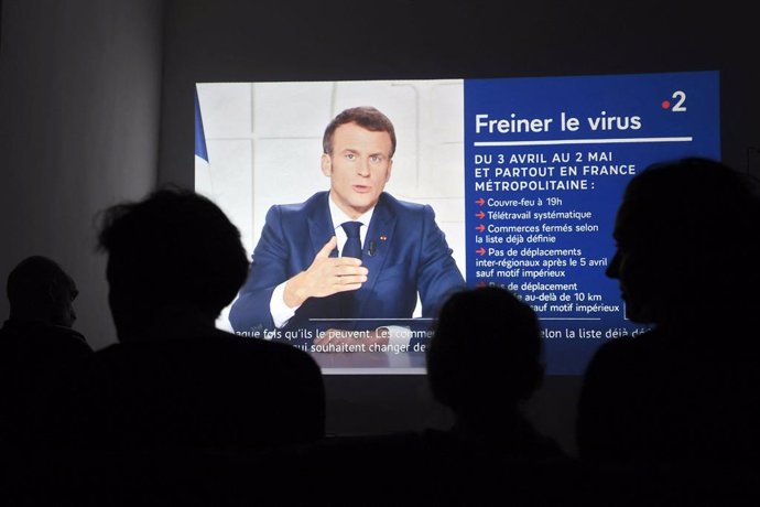 31 March 2021, France, Marseille: People listen to French president Emmanuel Macron while delivering a speech from the Elysee palace, on the new COVID-19 restrictions. Photo: Nicolas Tucat/AFP/dpa