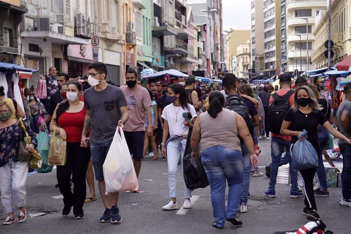 Archivo - Un grupo de personas camina en una de las zonas comerciales de Sao Paulo.