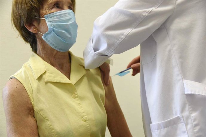 Una sanitaria vacuna a una mujer mayor de 80 años con la dosis de Moderna en el hospital Álvaro Cunqueiro de Vigo, en Vigo, Pontevedra,