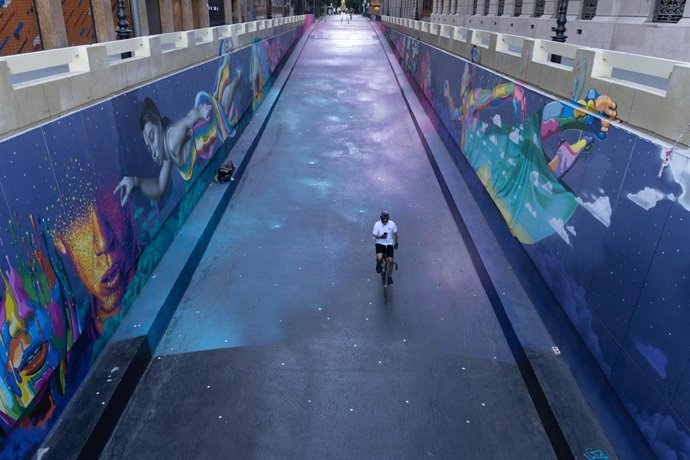 Un ciclista circula por una calle vacía.