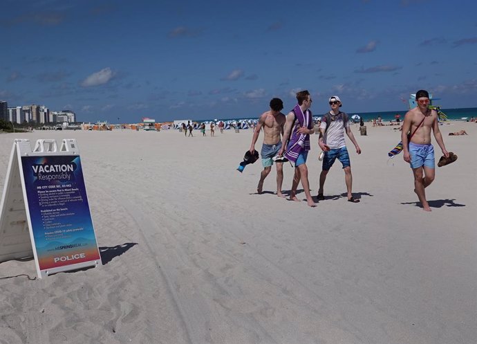 Varias personas caminan por la playa en Miami