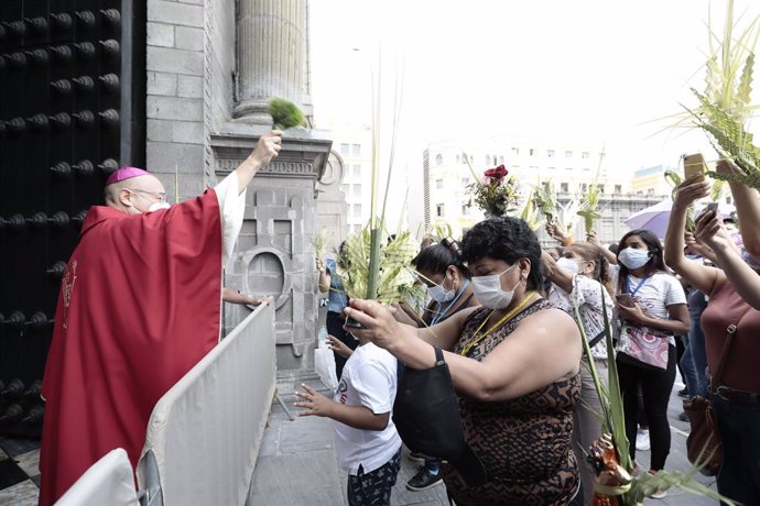 28 March 2021, Peru, Lima: A priest blesses worshippers outside the Basilica of St. Francis in Lima. Photo: El Comercio/GDA via ZUMA Wire/dpa