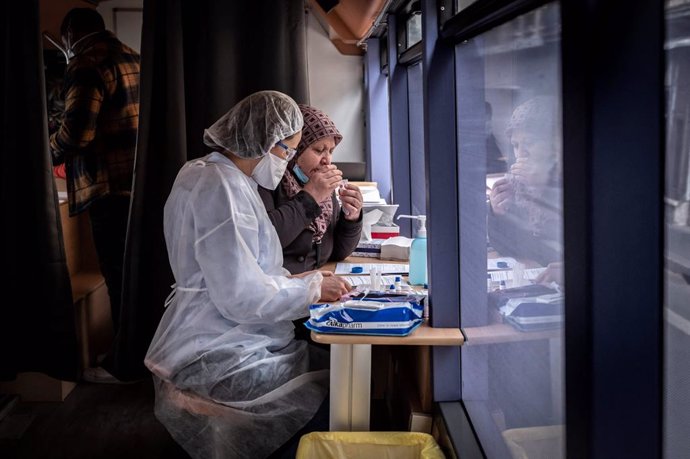 Archivo - 22 February 2021, France, Saint-Etienne: A patient sits next to a medical worker in protective clothing as she gives a sample for a Corona test at a testing station on a bus. The second mass testing campaign to contain the Corona pandemic is u
