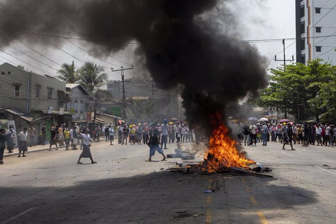 31 March 2021, Myanmar, Yangon: Protesters stand behind burning tires during a demonstration against the military coup and the detention of civilian leaders. Photo: Thuya Zaw/ZUMA Wire/dpa