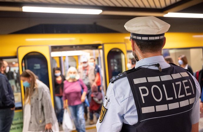 Archivo - Un policía vigila el uso de mascarilla en el metro de Stuttgart
