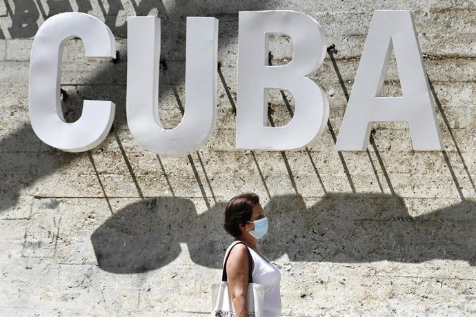 Una mujer con mascarilla pasea por La Habana