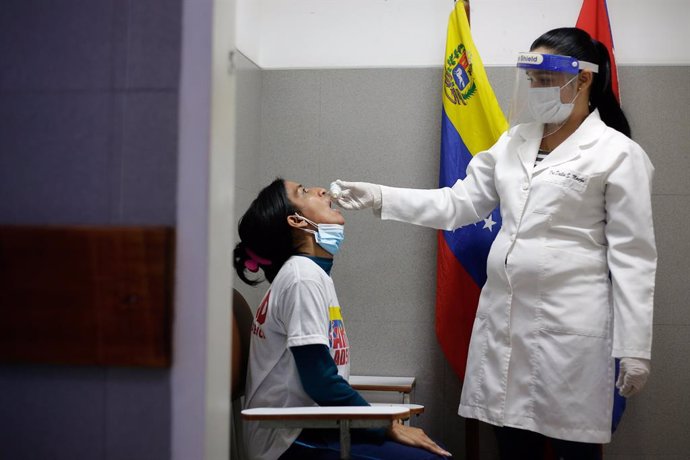 25 March 2021, Venezuela, Caracas: A doctor from the CDI health center administers a dose of Carvativir, popularly known as the "miracle droplet against Corona", to a health worker. Photo: Jesus Vargas/dpa