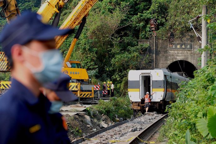 03 April 2021, Taiwan, Hualien: A damaged train carriage is lifted and removed from a track for clearance after a train collided with a truck and derailed in eastern Taiwan the day before. Flags were at half-mast in Taiwan on Saturday and were set to st
