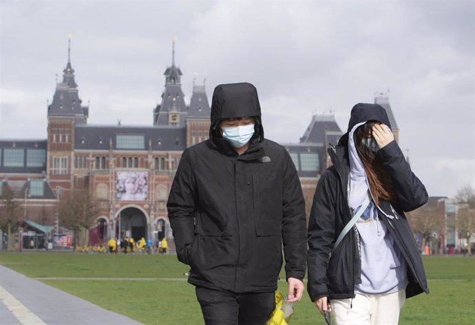 Archivo - Turistas pasean con mascarilla por Ámsterdam 
