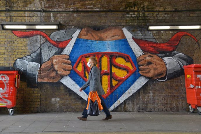 01 April 2021, United Kingdom, London: A woman walks past a graffiti tribute to National Health Service in Waterloo, amid the coronavirus (COVID-19) pandemic. Photo: Thomas Krych/SOPA Images via ZUMA Wire/dpa
