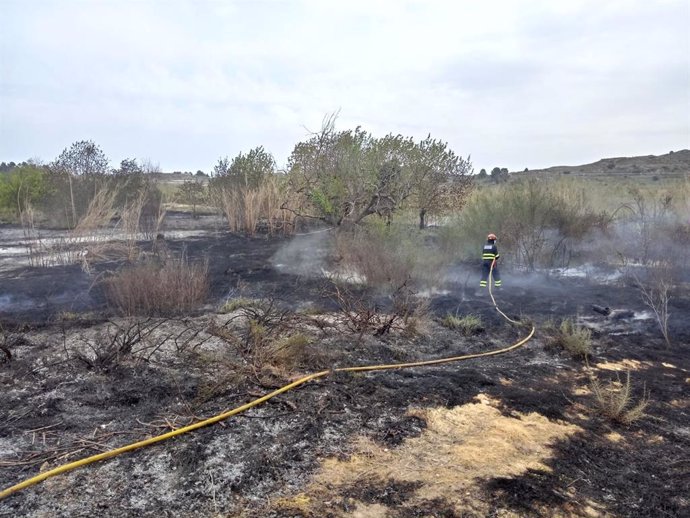 Un bombero de la DPT sofoca un incendio de matorral en Castelserás (Teruel).